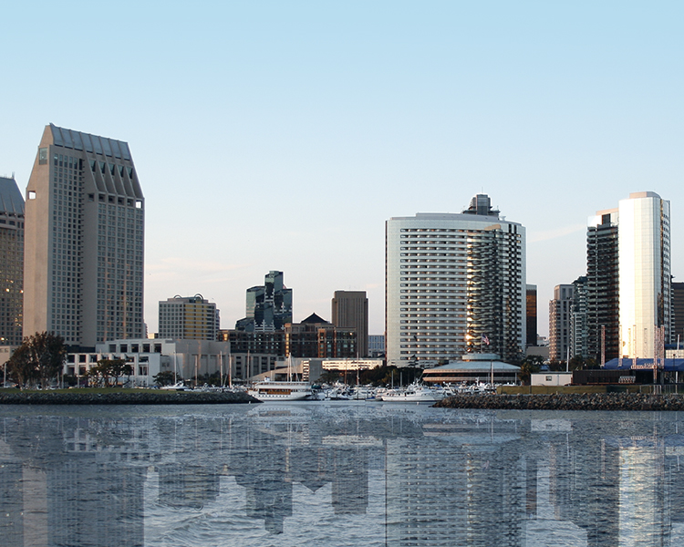 San Diego skyline reflected on water at dusk.