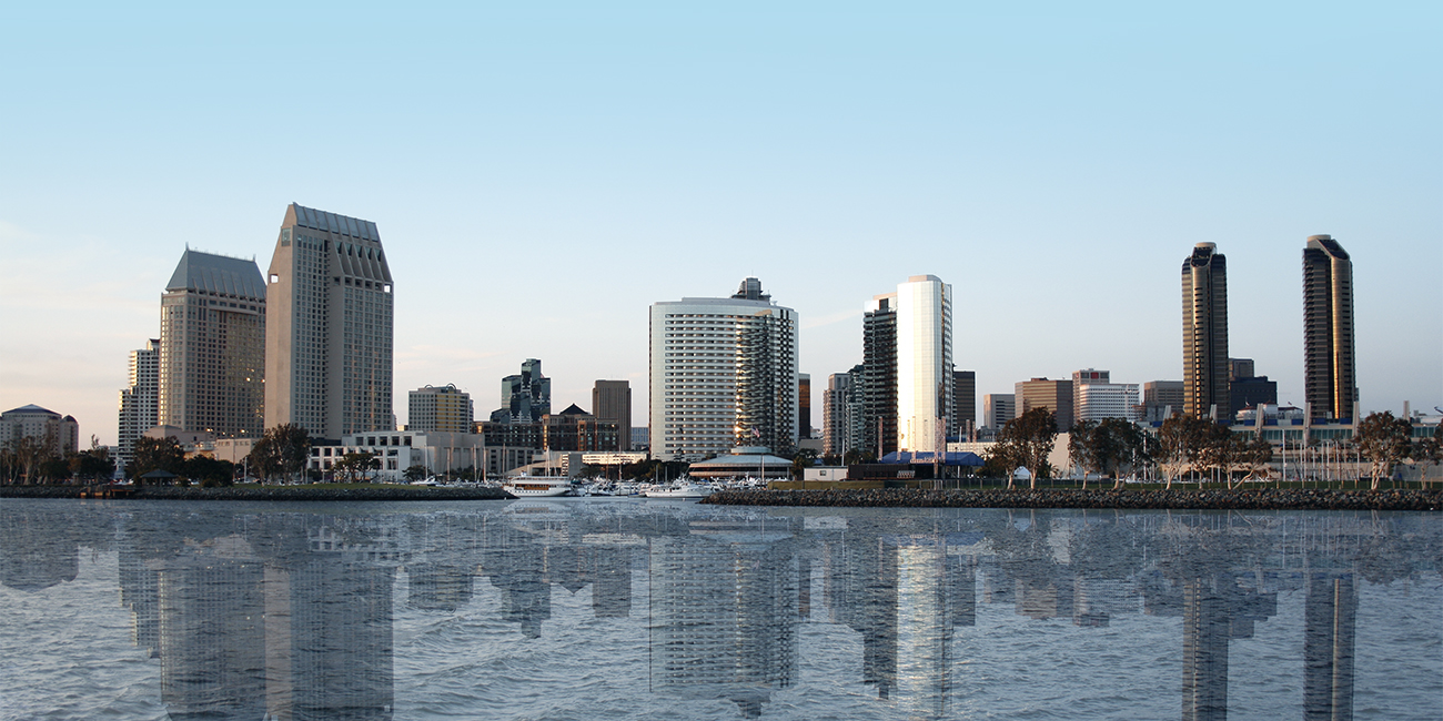 San Diego skyline reflected on water at dusk.